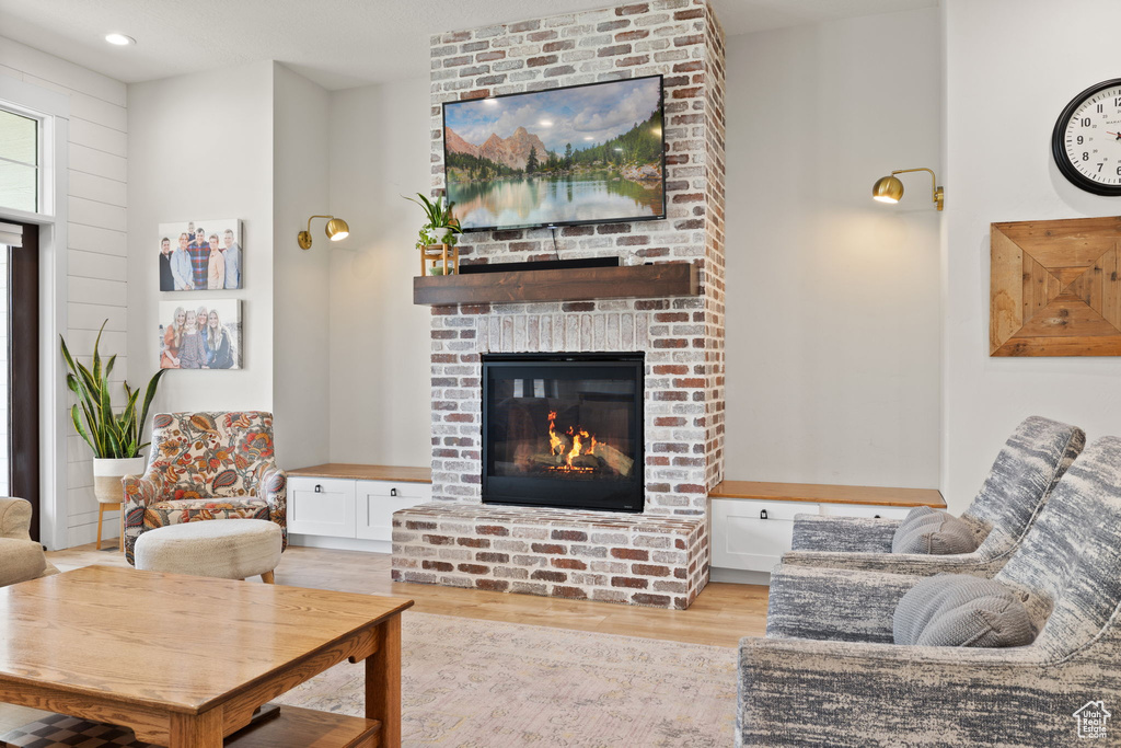 Living room featuring recessed lighting, wood finished floors, and a fireplace