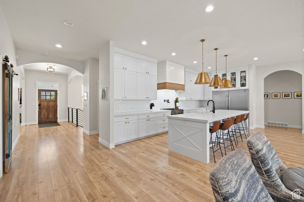 Kitchen with visible vents, light countertops, light wood finished floors, and tasteful backsplash