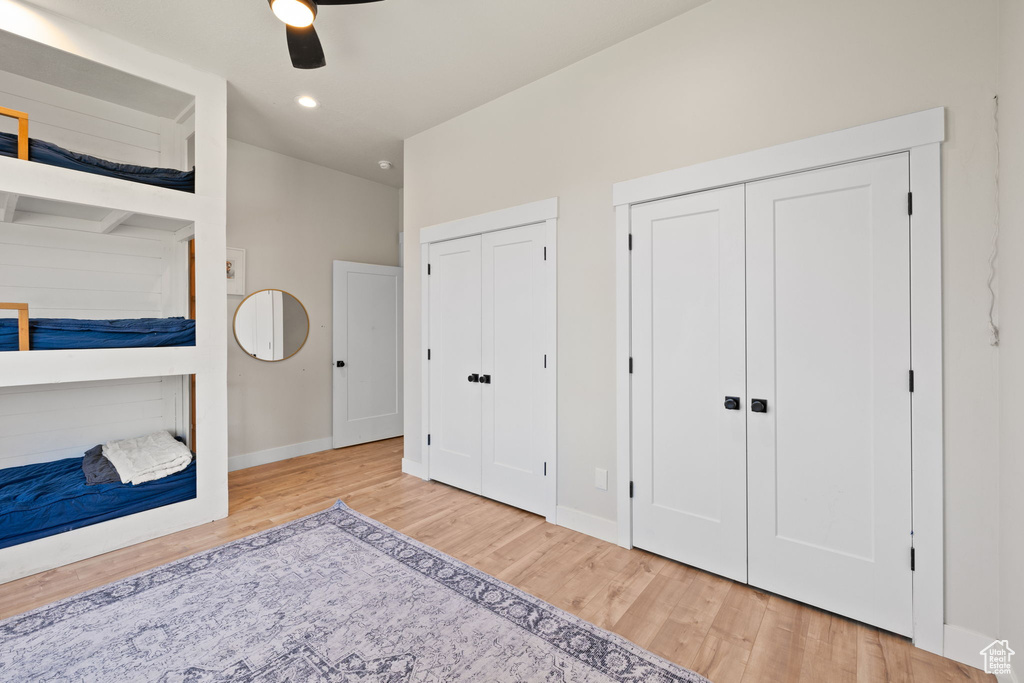 Bedroom featuring wood finished floors, two closets, baseboards, ceiling fan, and recessed lighting
