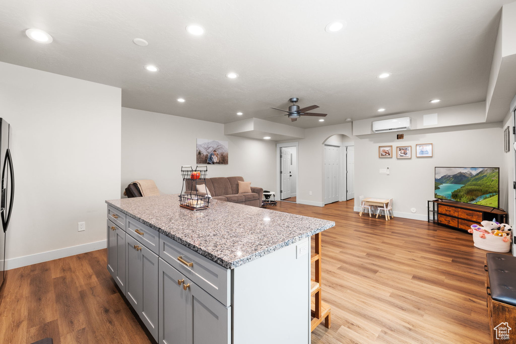 Kitchen with ceiling fan, a center island, recessed lighting, gray cabinetry, and a wall mounted AC