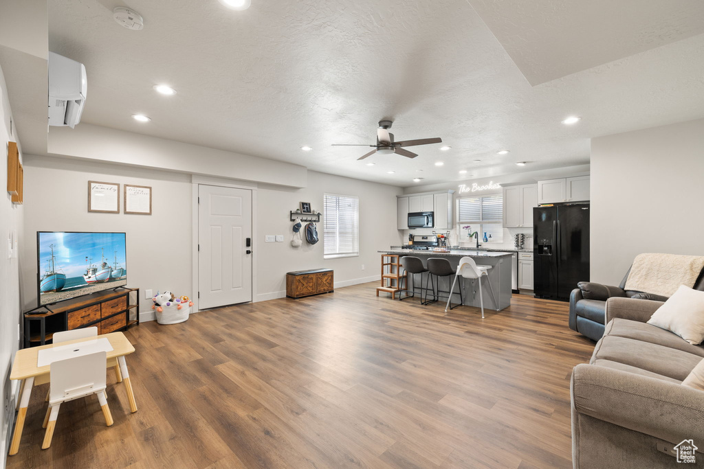 Living room with recessed lighting, baseboards, ceiling fan, and wood finished floors