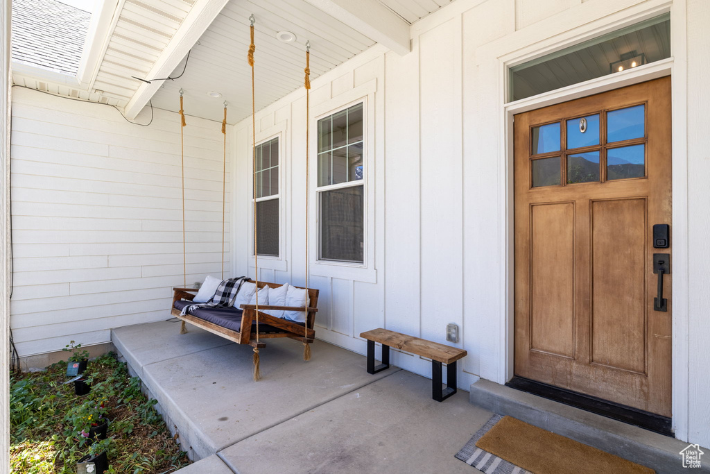 Entrance to property featuring board and batten siding and covered porch