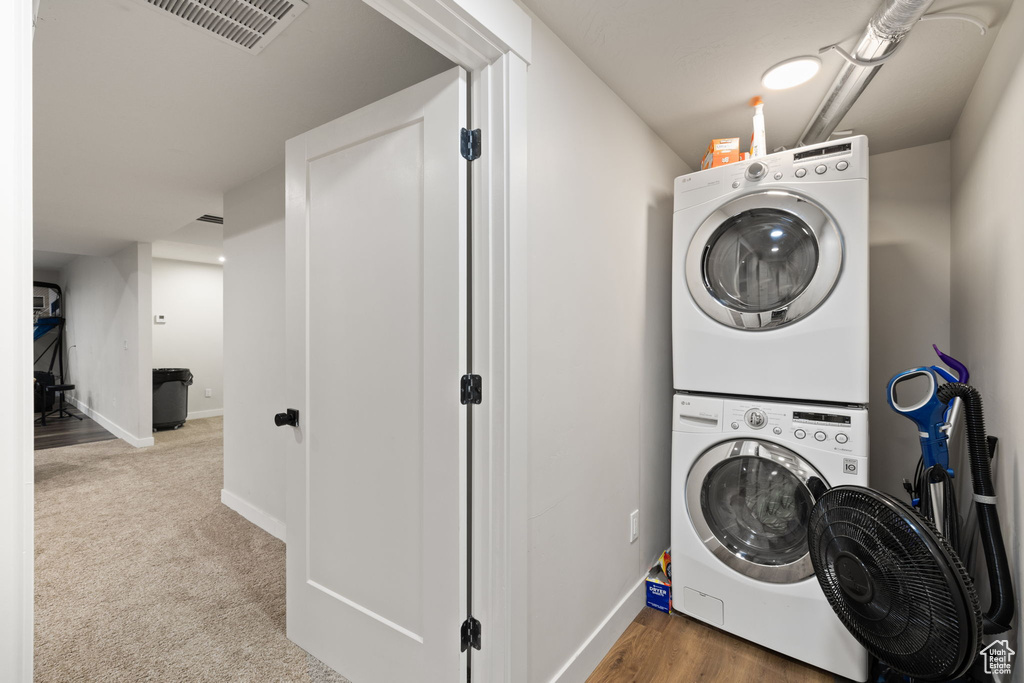 Laundry room featuring baseboards, stacked washer / drying machine, laundry area, and visible vents