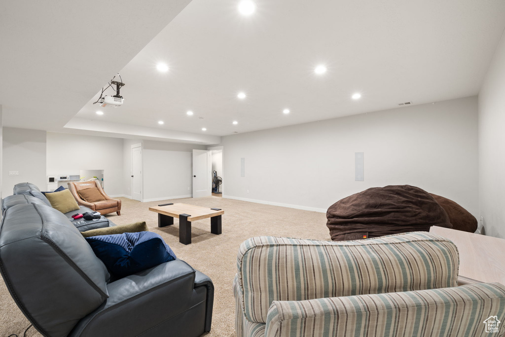 Living area featuring baseboards, light carpet, and recessed lighting