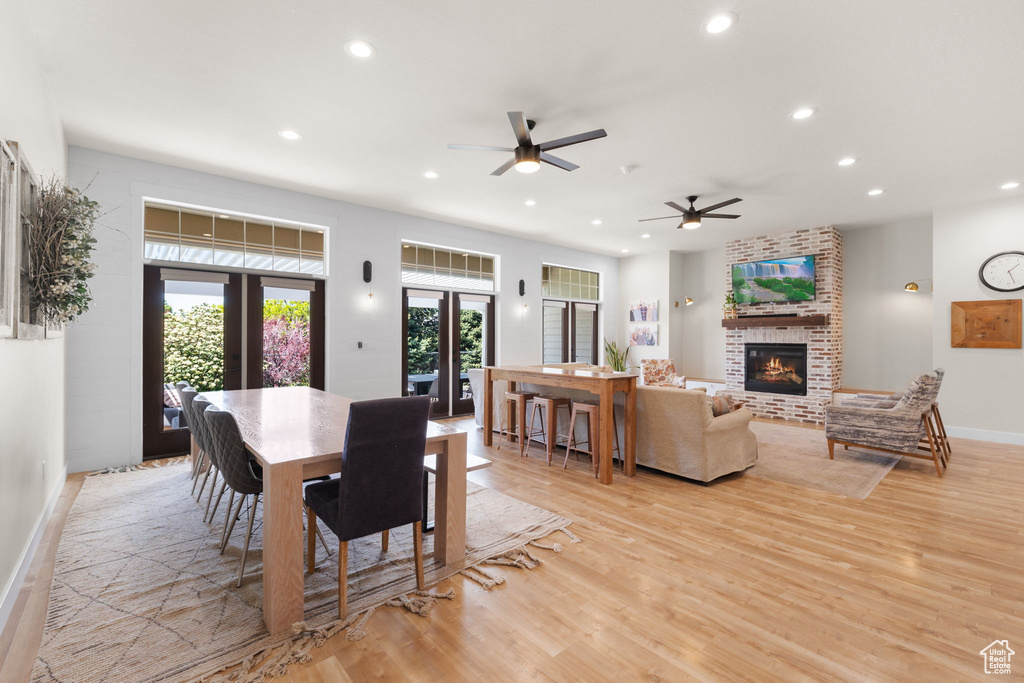 Dining space featuring recessed lighting, a ceiling fan, a fireplace, and light wood-type flooring