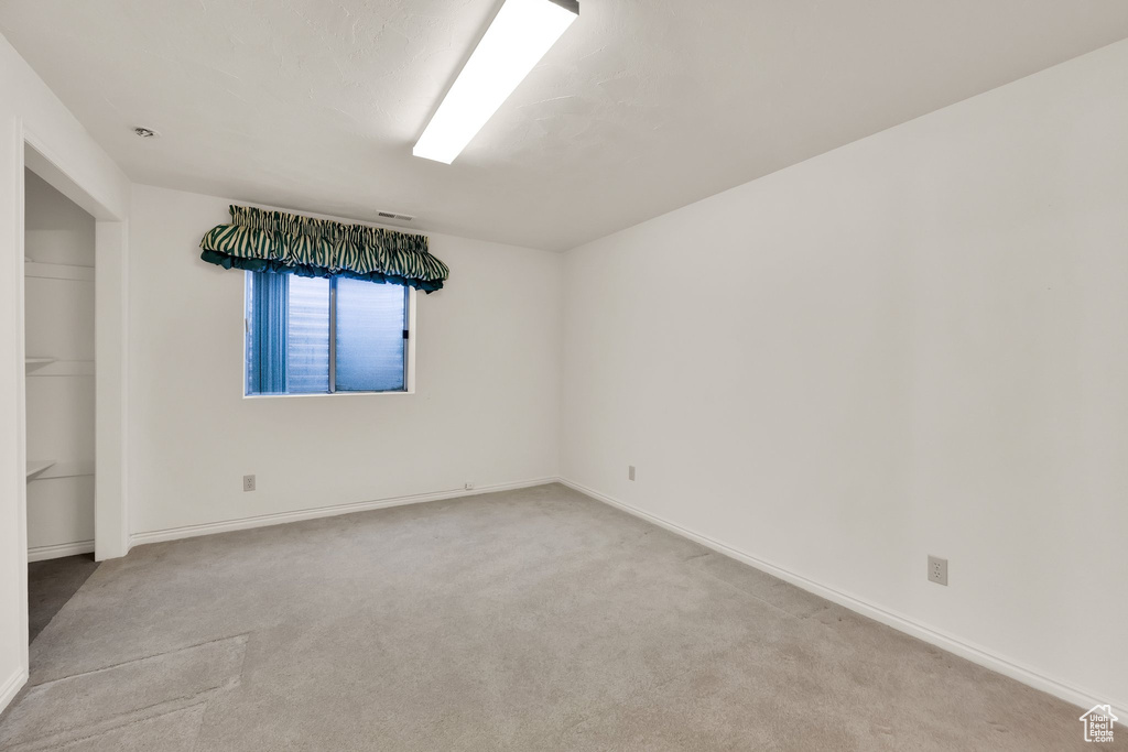 Unfurnished room with light colored carpet and baseboards