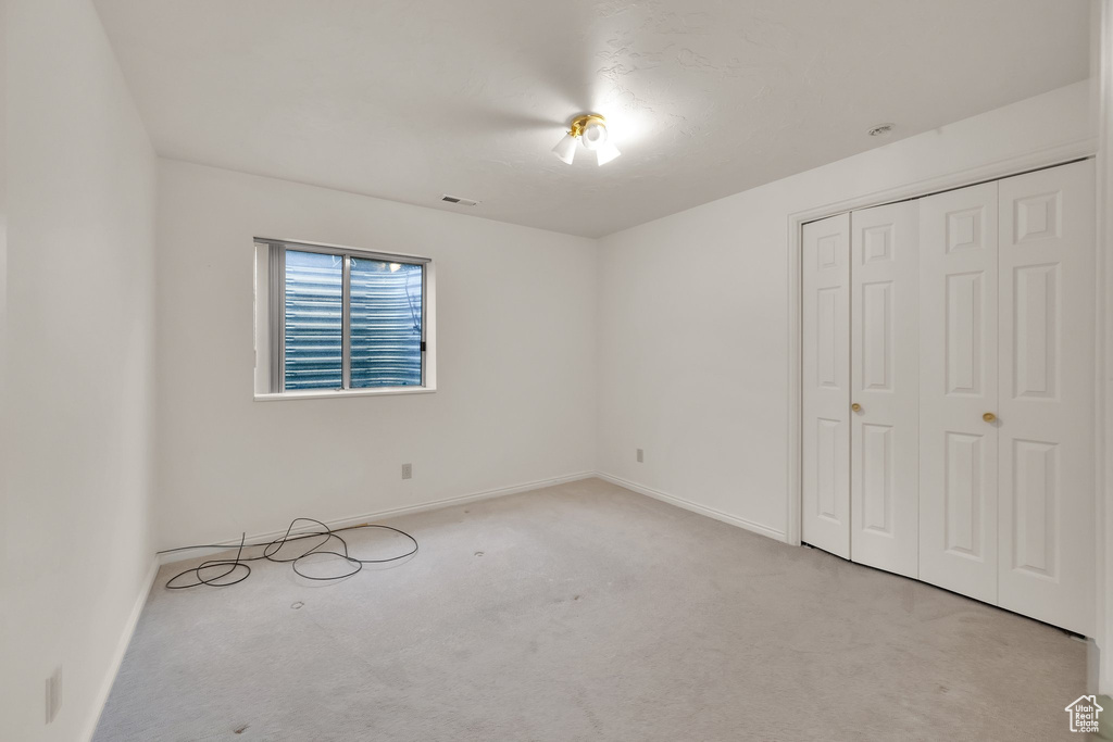 Unfurnished bedroom with carpet flooring, baseboards, and a closet