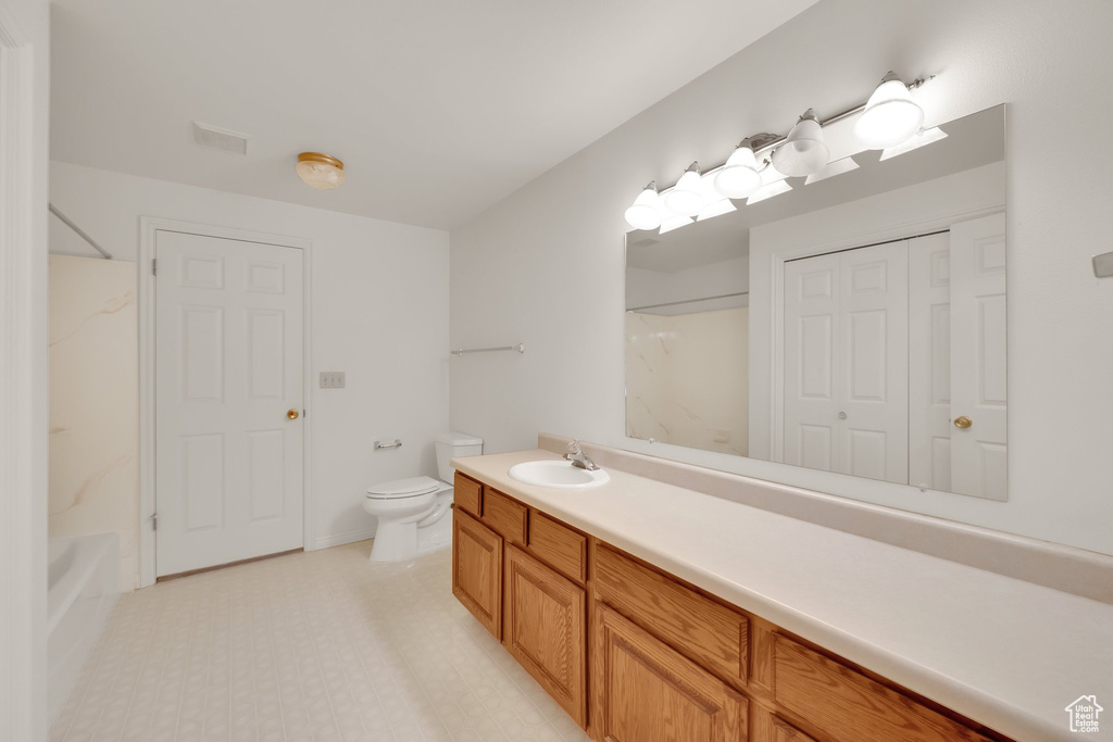 Bathroom featuring toilet, vanity, and shower / washtub combination