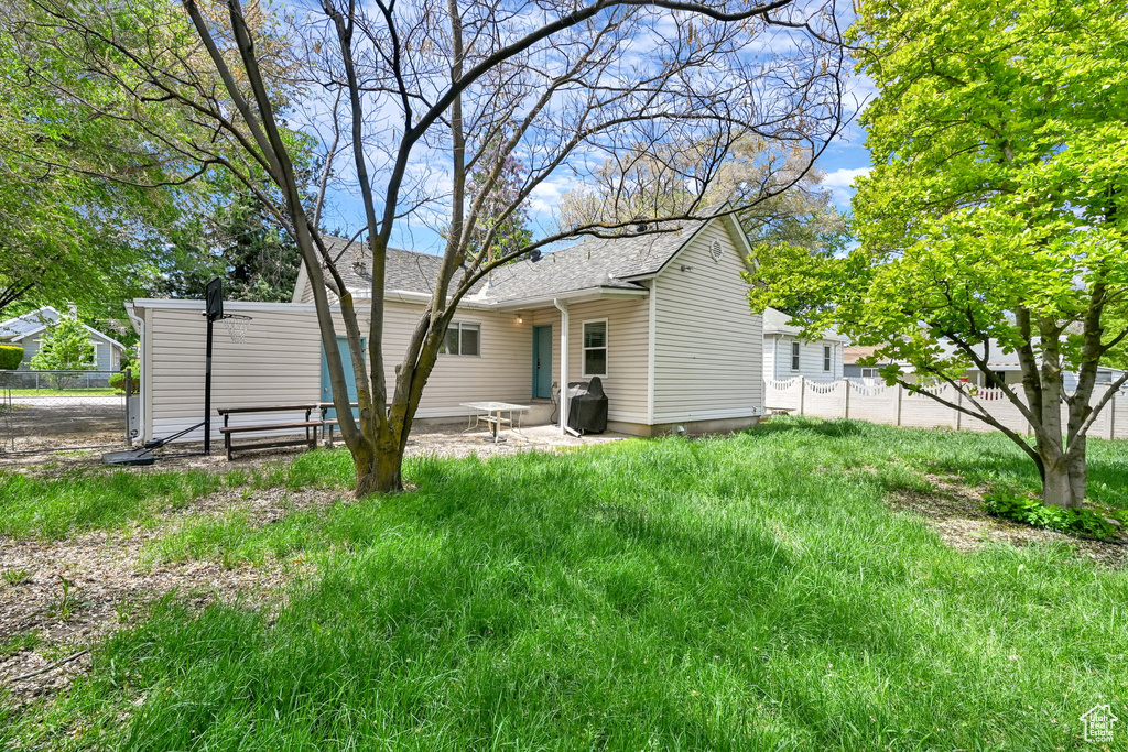 Back of property with fence and a patio area