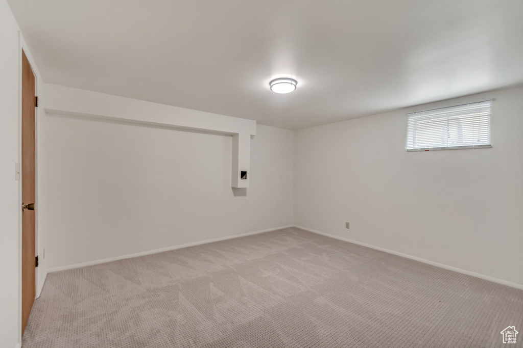 Basement with light colored carpet and baseboards