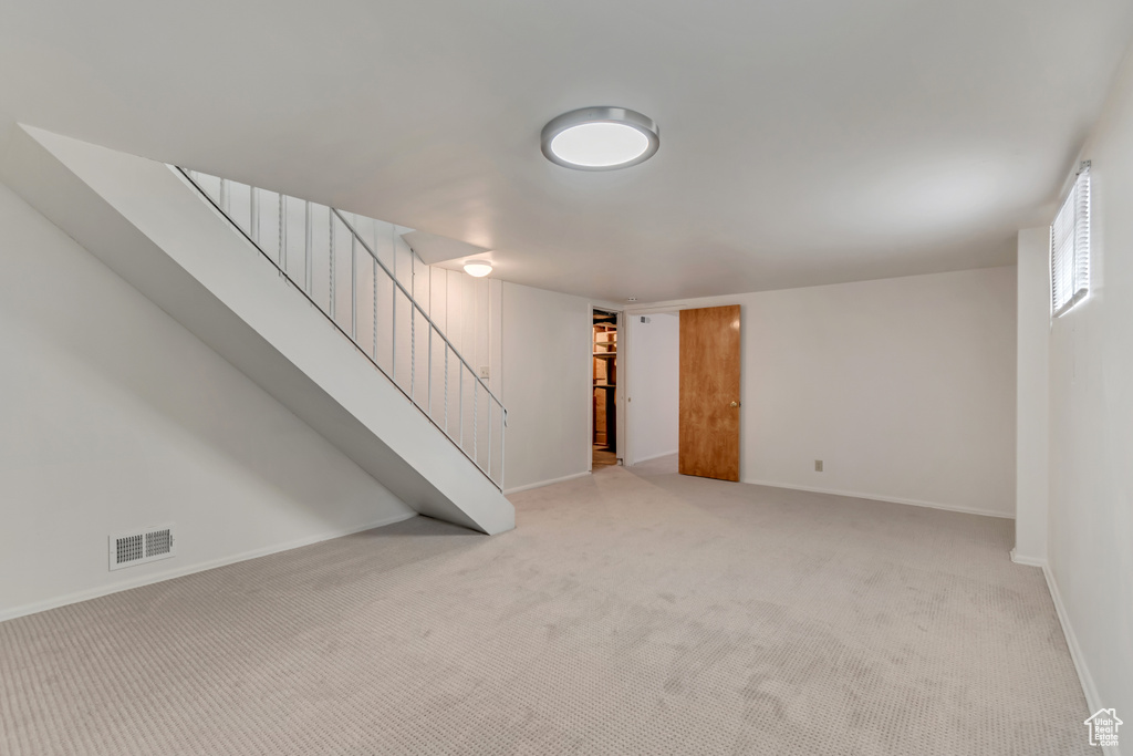 Finished basement with stairway, carpet, and baseboards