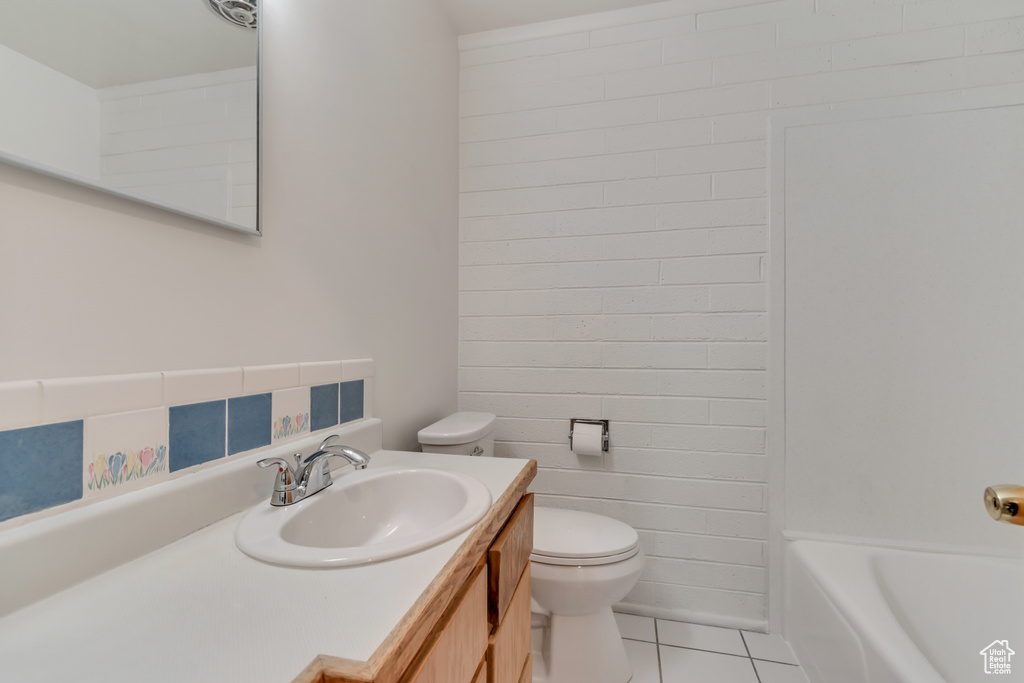 Full bathroom with toilet, tile patterned flooring, and vanity