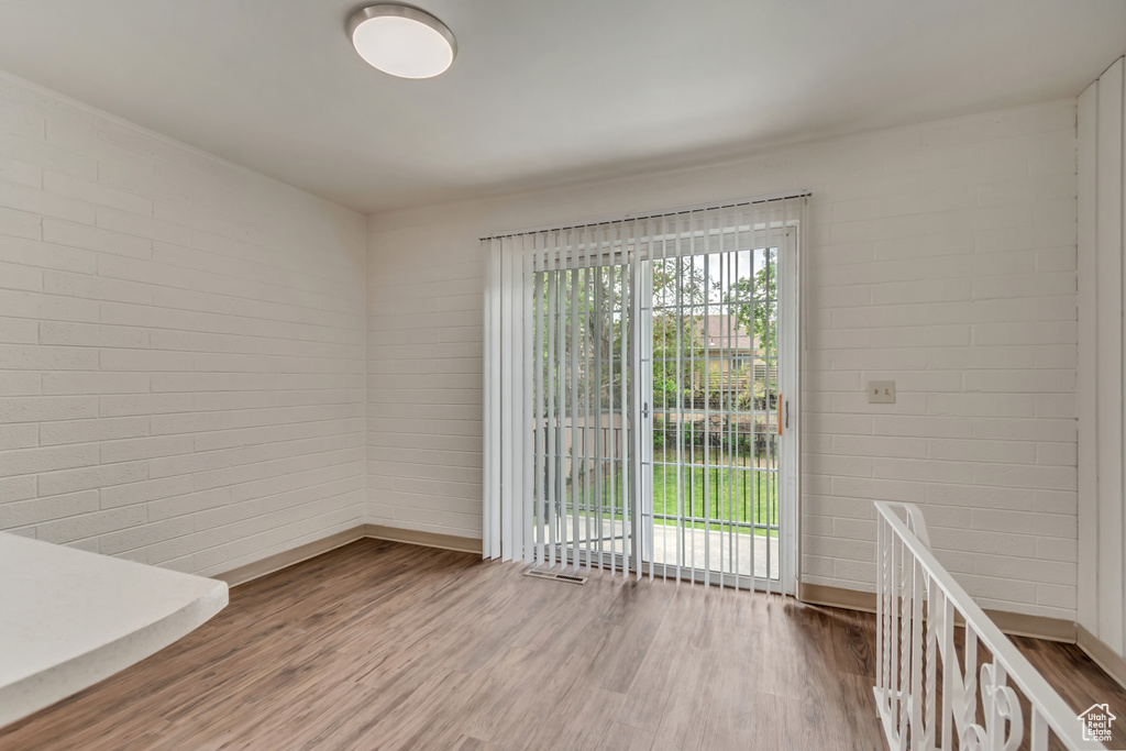 Unfurnished dining area with wood finished floors and baseboards