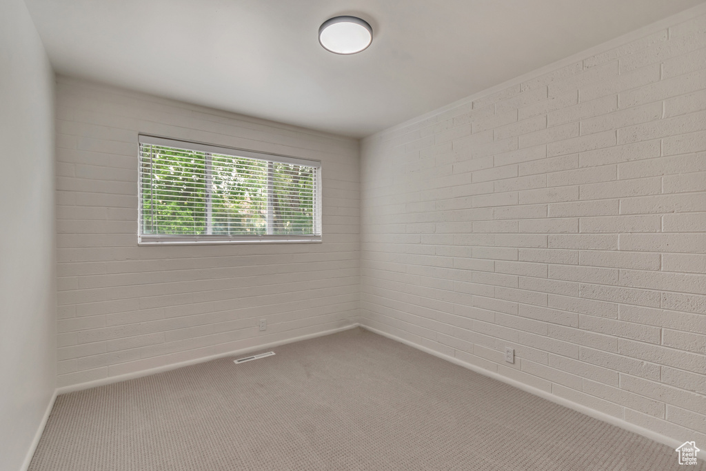 Carpeted spare room featuring baseboards