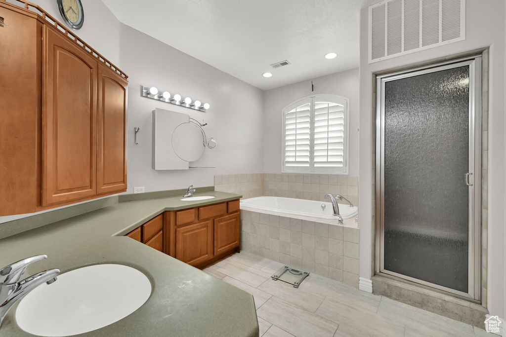 Full bath with a shower stall, a garden tub, vanity, and visible vents