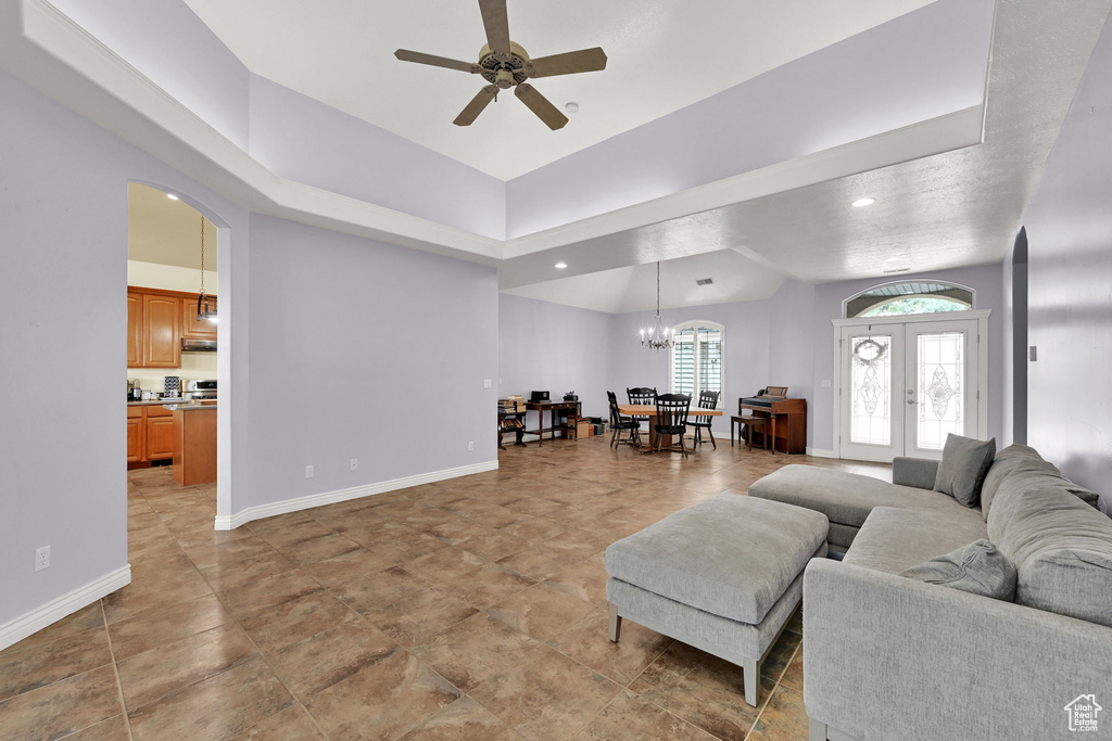 Living room featuring french doors, recessed lighting, baseboards, ceiling fan with notable chandelier, and arched walkways