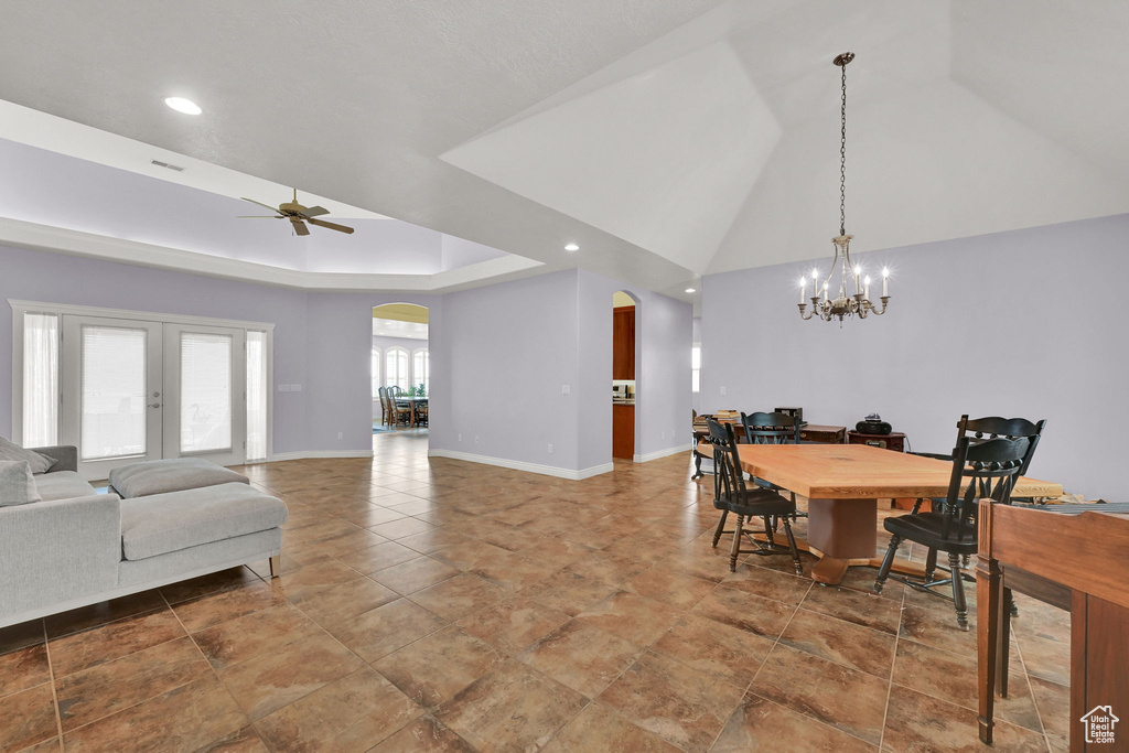 Dining space featuring arched walkways, baseboards, recessed lighting, and ceiling fan with notable chandelier