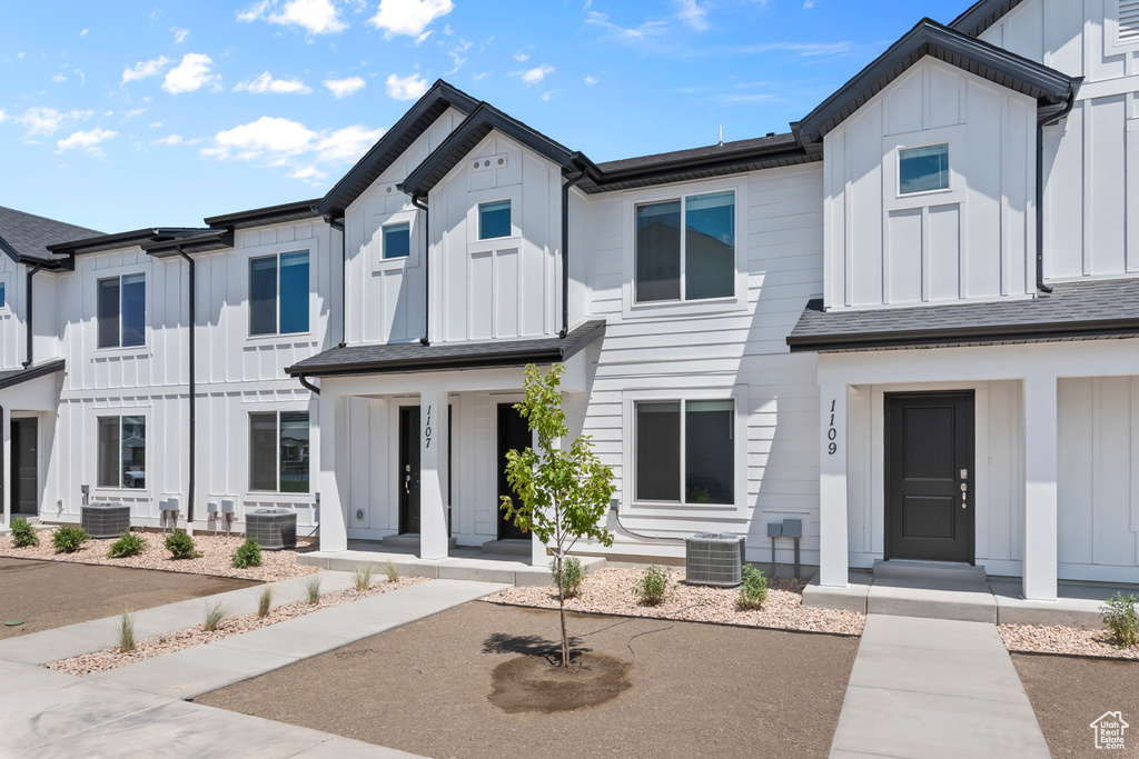 View of front of home featuring board and batten siding and central AC unit