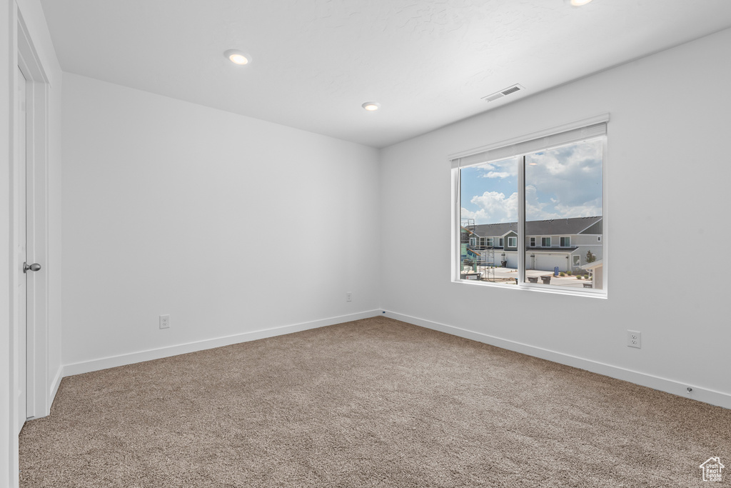 Spare room featuring carpet flooring, baseboards, and recessed lighting