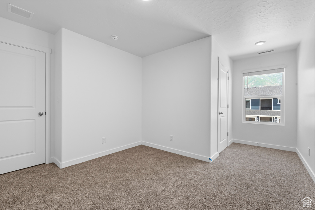 Unfurnished room featuring carpet floors and baseboards