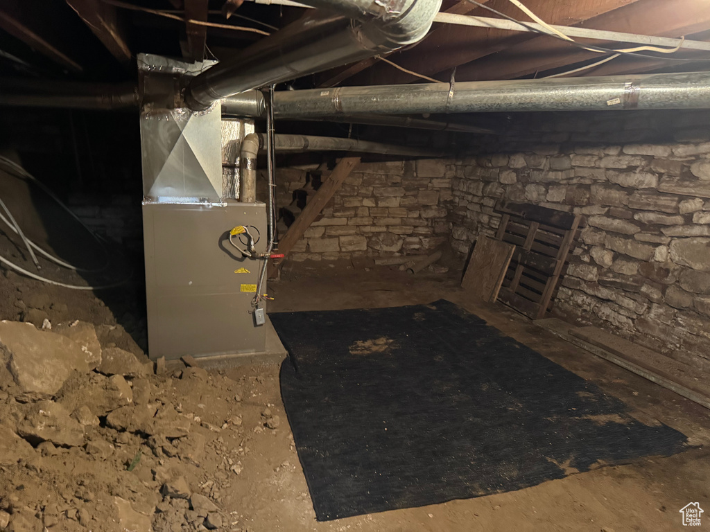 Unfinished basement featuring heating unit