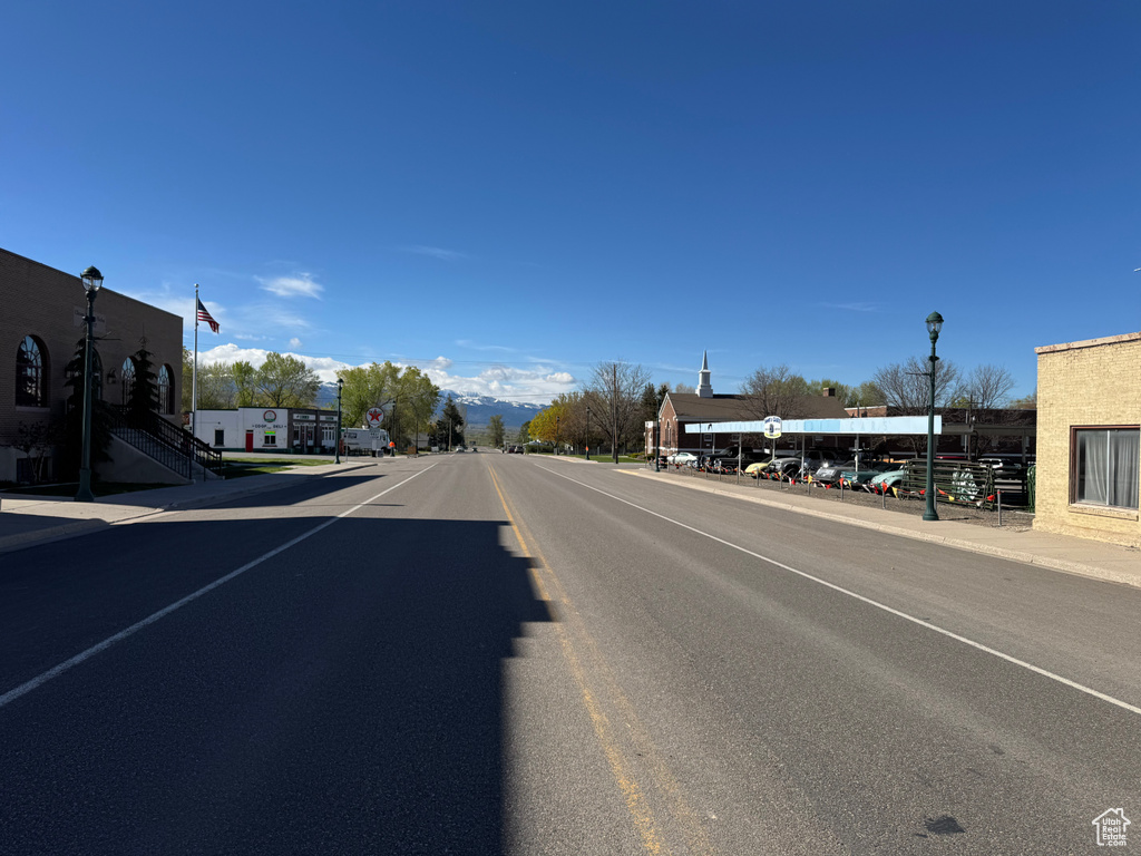 View of asphalt road featuring street lights