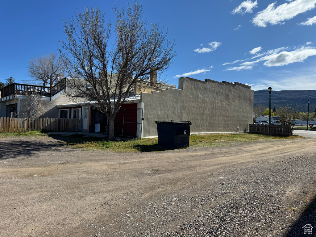 View of property exterior featuring fence and a mountain view