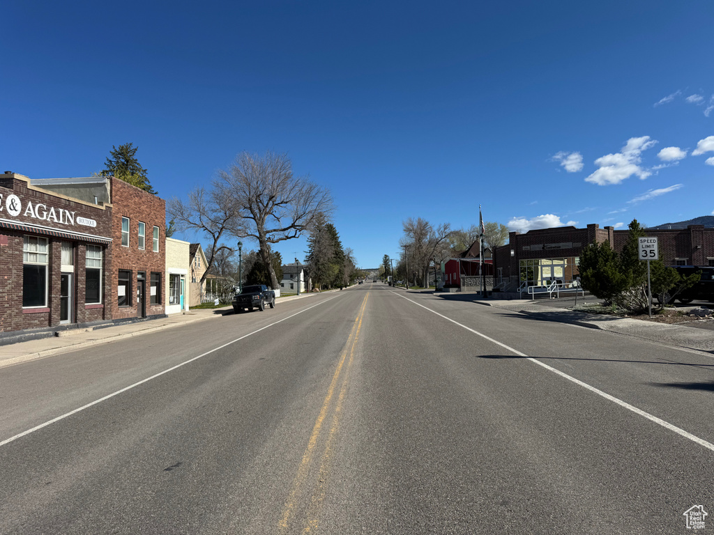 View of asphalt street featuring sidewalks and curbs
