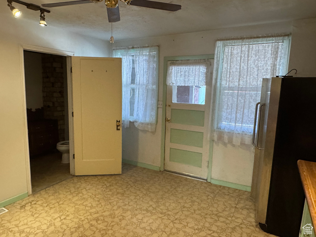Spare room with tile patterned floors, a ceiling fan, and baseboards