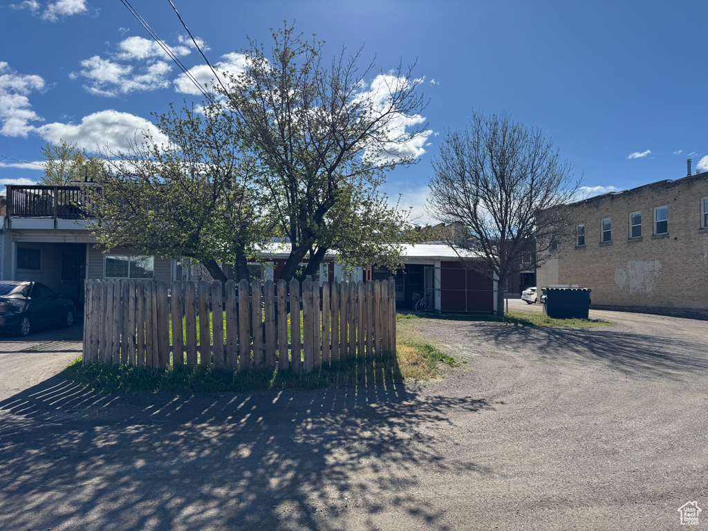 View of front facade with fence and dirt driveway