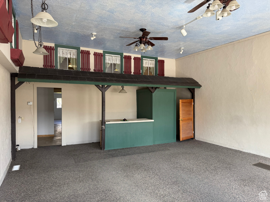 Unfurnished living room with ceiling fan, carpet floors, and a textured ceiling