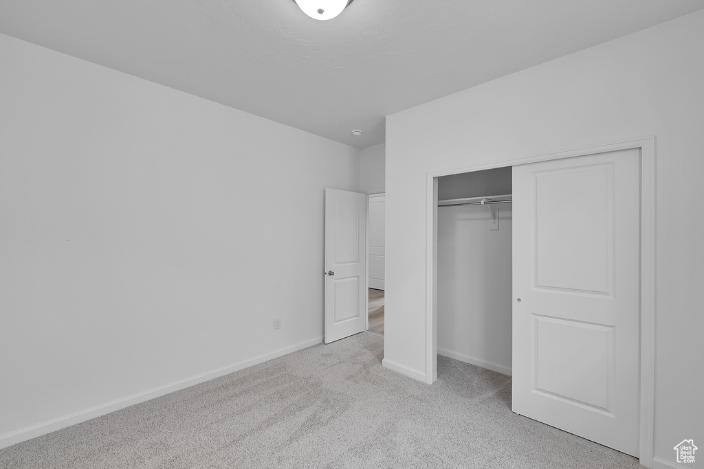 Unfurnished bedroom with carpet flooring, baseboards, and a closet