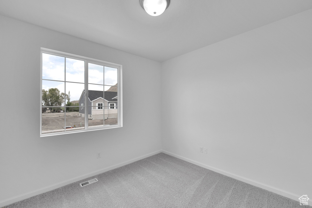 Carpeted empty room with baseboards
