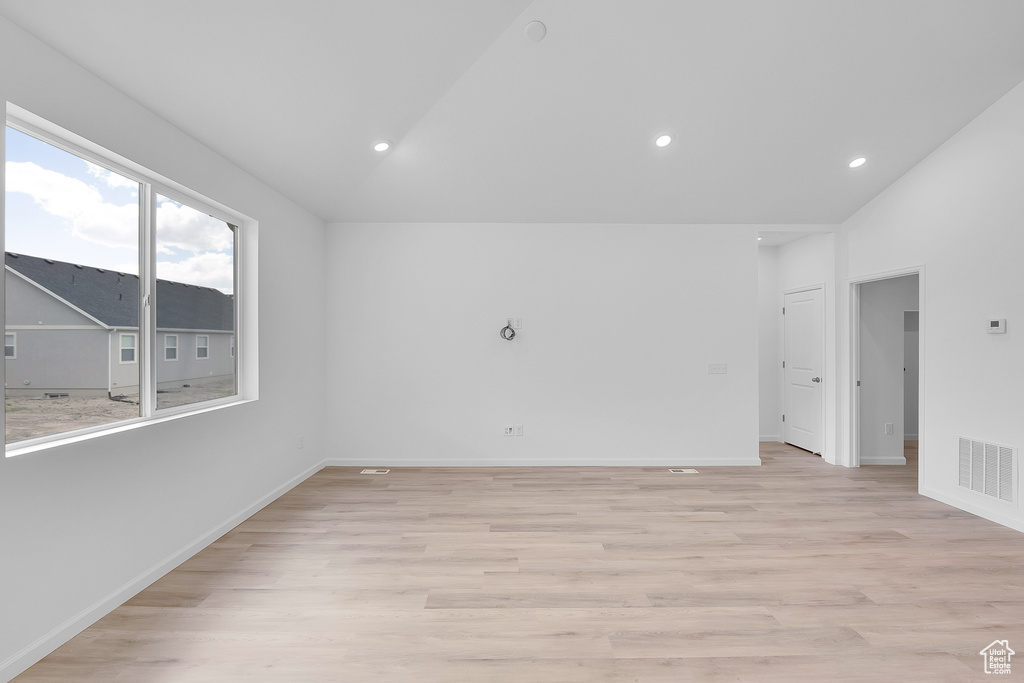 Unfurnished room with vaulted ceiling, light wood finished floors, baseboards, and recessed lighting