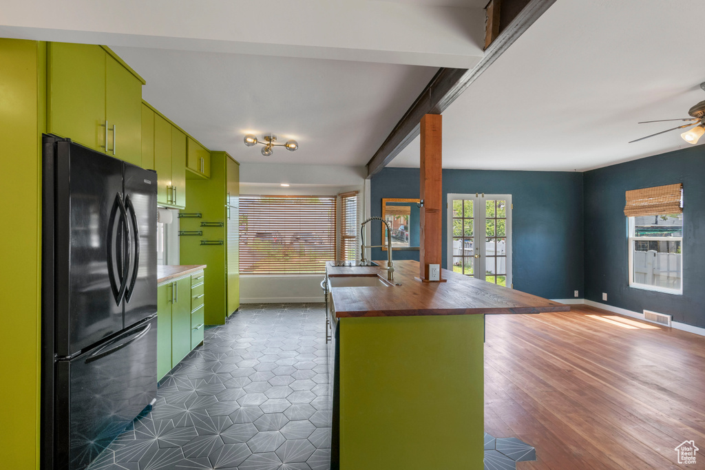 Kitchen with freestanding refrigerator, a sink, butcher block counters, open floor plan, and a ceiling fan