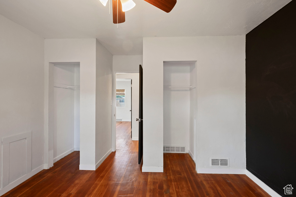 Unfurnished bedroom featuring wood finished floors, baseboards, and a ceiling fan