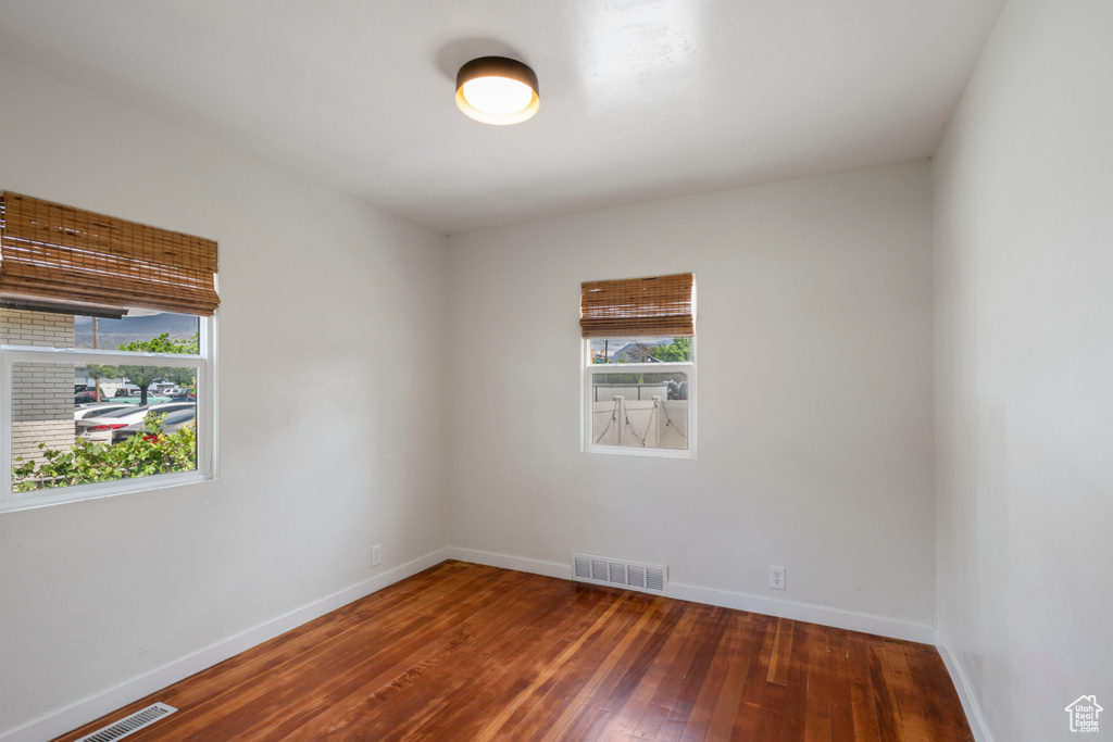 Empty room with wood-type flooring and baseboards