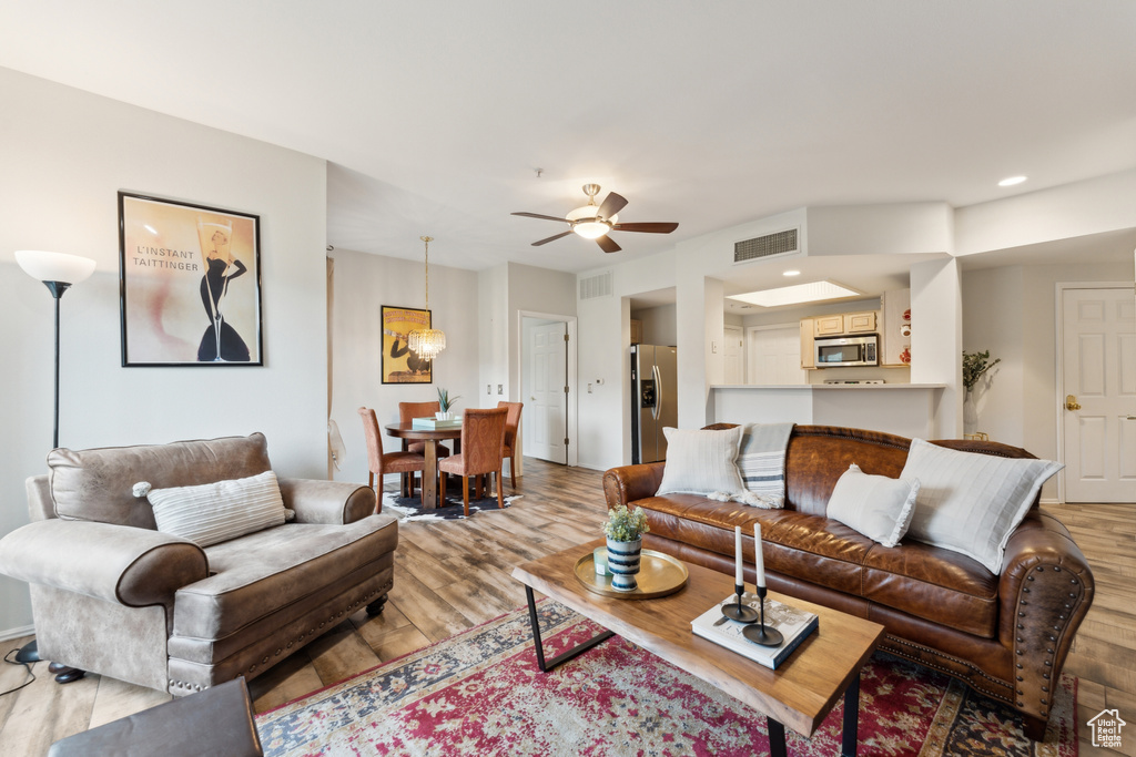 Living room featuring a ceiling fan, recessed lighting, visible vents, and wood finished floors