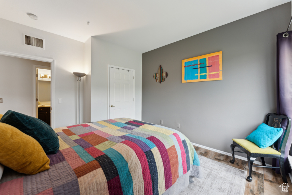 Bedroom with visible vents, wood finished floors, and baseboards