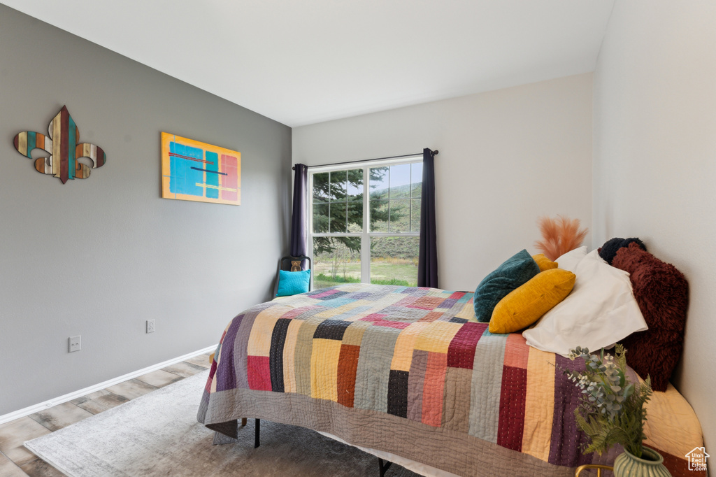 Bedroom featuring baseboards and wood finished floors