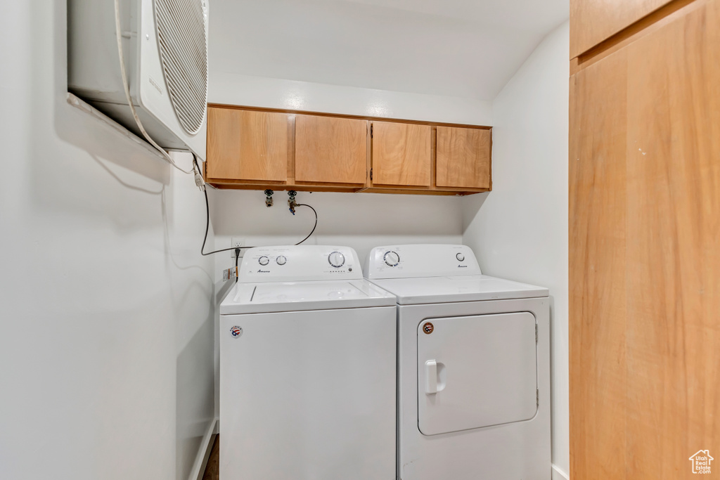 Laundry area with cabinet space and washer and clothes dryer