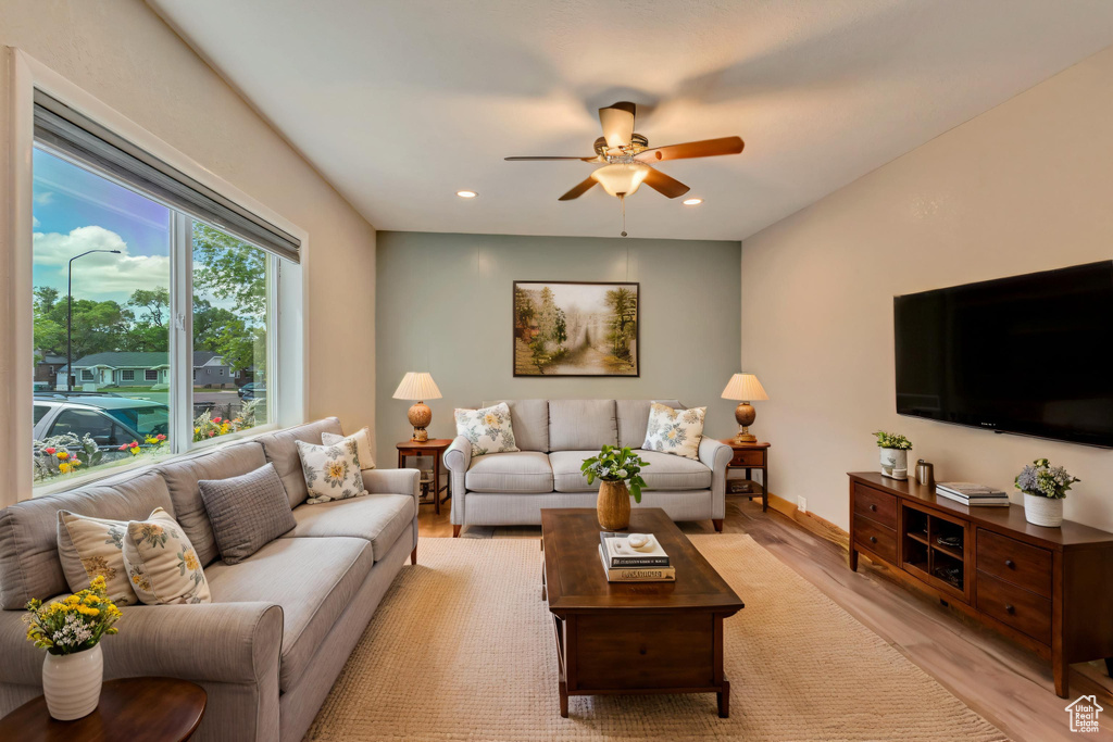 Living area with light wood-style floors, a ceiling fan, and recessed lighting