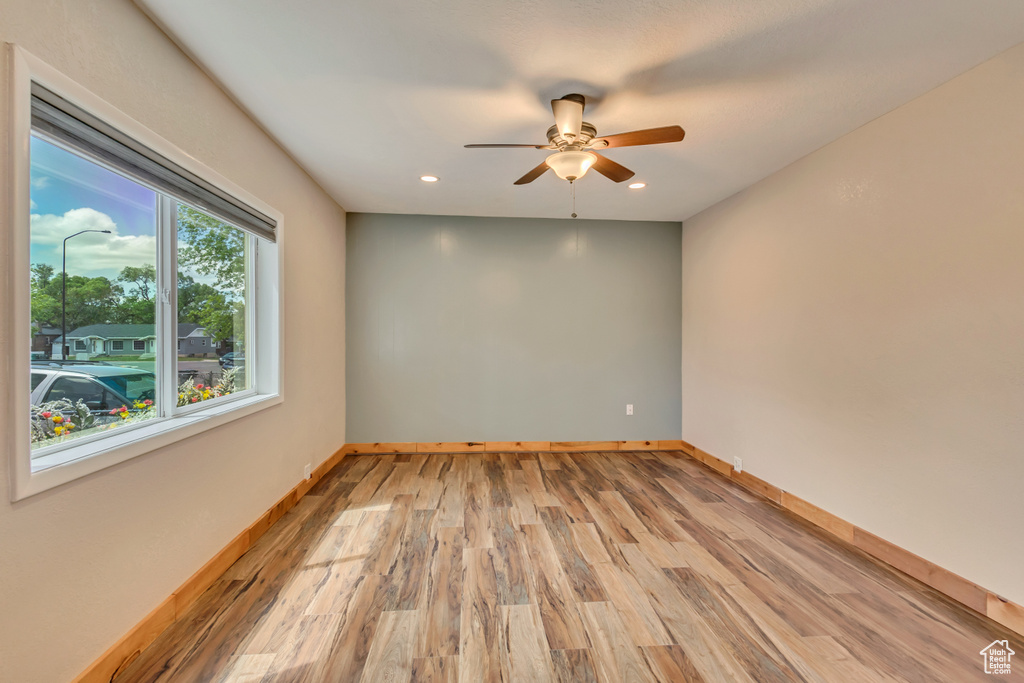 Unfurnished room featuring a ceiling fan, baseboards, light wood-type flooring, and recessed lighting