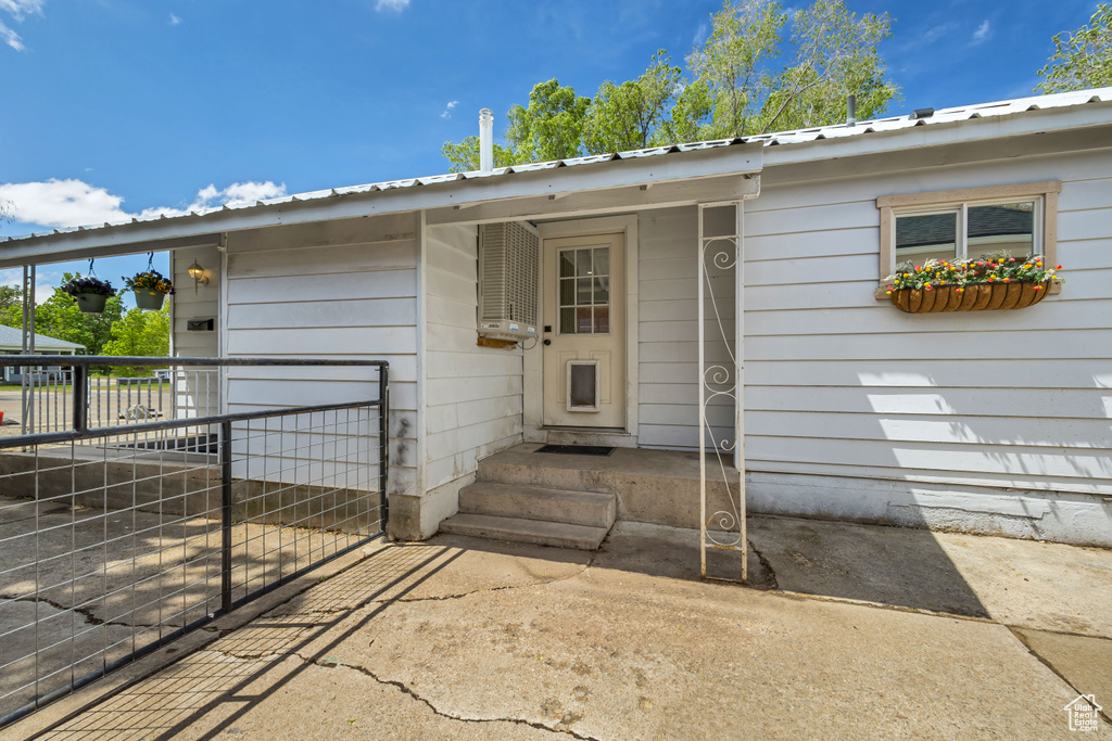Entrance to property with fence and metal roof