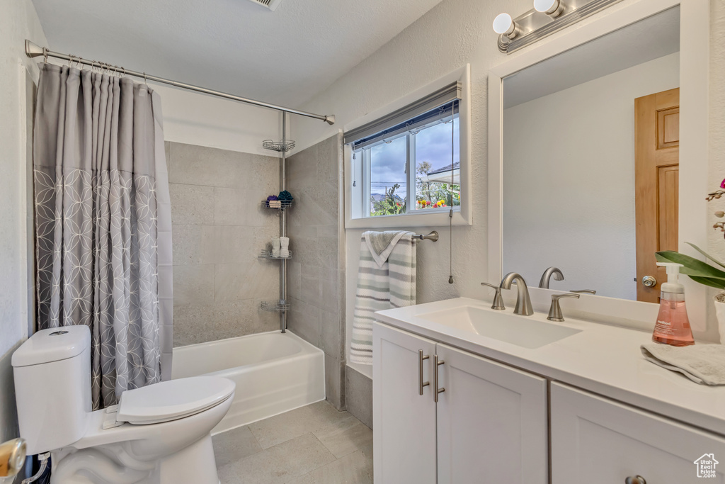 Bathroom with toilet, shower / bath combo, vanity, and tile patterned floors