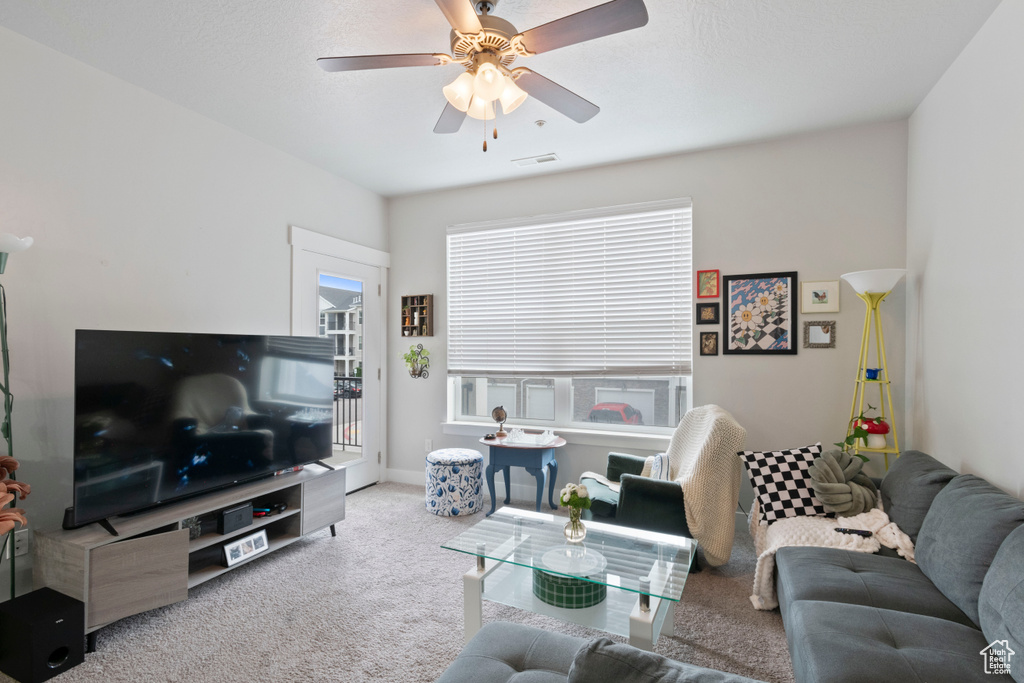Carpeted living area with a ceiling fan