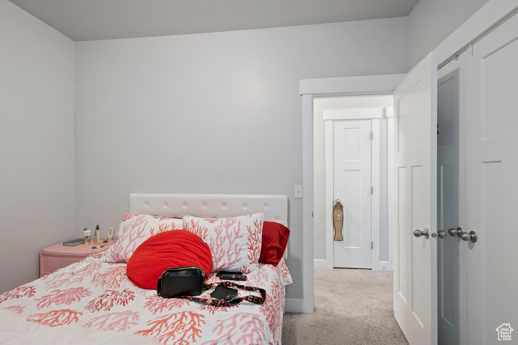 Bedroom with carpet flooring, baseboards, and a closet