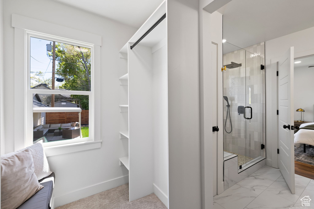 Full bathroom featuring a stall shower, connected bathroom, and baseboards