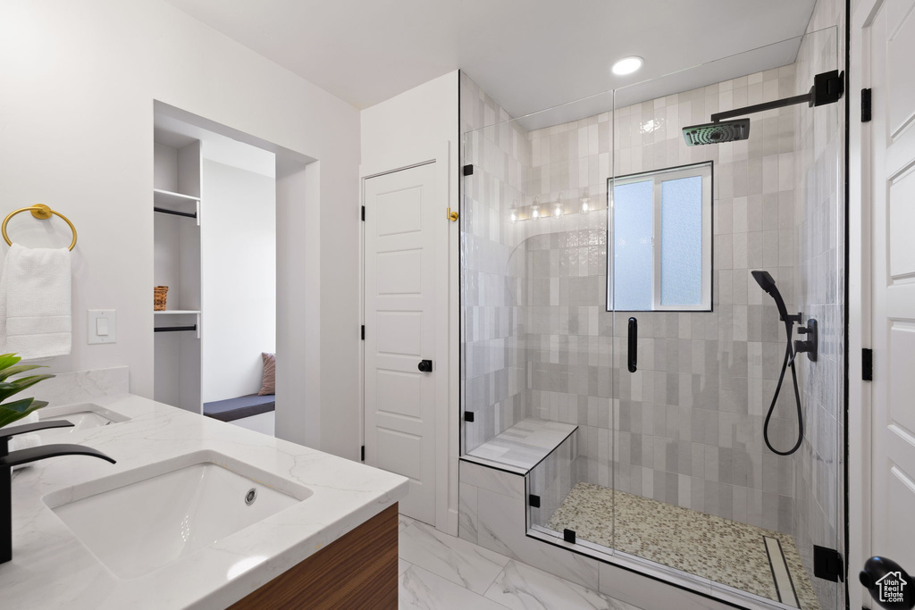 Full bathroom with a stall shower, double vanity, marble finish floors, and recessed lighting
