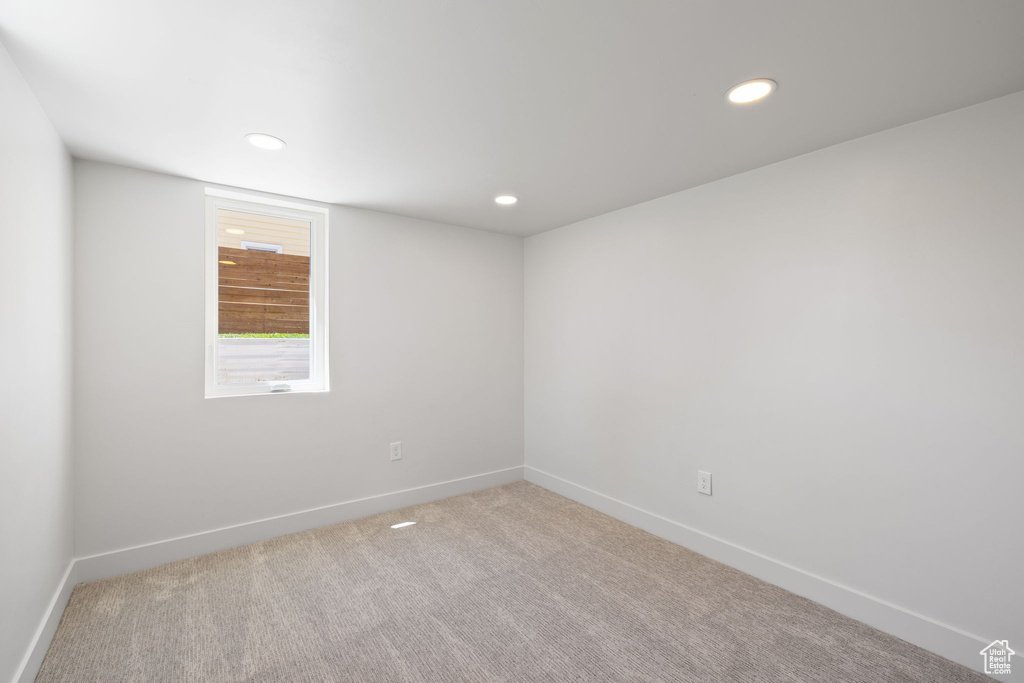 Spare room featuring baseboards, light carpet, and recessed lighting